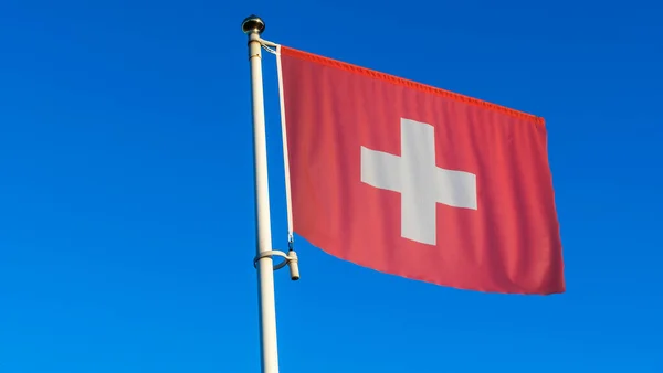 在蓝天前的旗杆上挂满了太阳光和镜头耀斑的瑞士国旗 外交概念 国际关系 案文的篇幅 — 图库照片