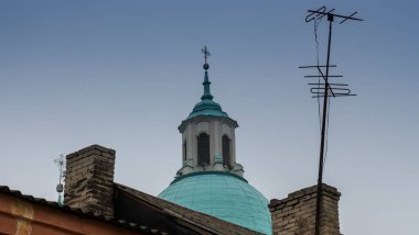 Televizyon antenleri ve apartman çatılarından çapraz görüşlü Katolik alemi. Tapma ve teknoloji konsepti.