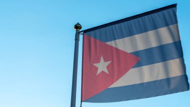 Ulusal Küba bayrağı mavi gökyüzünün önündeki bayrak direğinde güneş ışınları ve merceklerle parlıyor. Diplomasi konsepti. Uluslararası ilişkiler. Metin için boşluk.