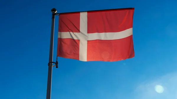 丹麦国旗在蓝天上闪烁着太阳光和透镜的光芒 外交概念 国际关系 案文的篇幅 — 图库照片