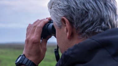 İnsanlar dürbünle sahadaki kuşlara ya da hayvanlara bakıyor. Doğada kuşları izleyerek zaman geçirmek. Vahşi yaşam konsepti.