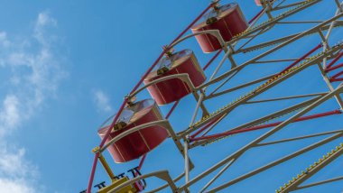 Kulübeli dönme dolap. Lunaparkta mavi gökyüzüne karşı atlıkarınca. Tatil kavramı.