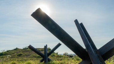 2. Dünya Savaşı 'ndan kalma demir tanksavar. Kirpi karşıtı dikenli tel mavi gökyüzü arka planında. Metin için boşluk.