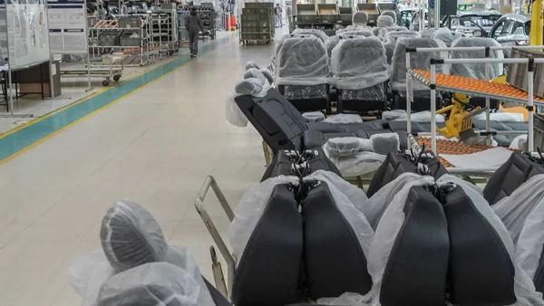 Depodaki koltuklar paketin içinde. Araba koltuğu montaj hattı çalışıyor. Endüstri kavramı.