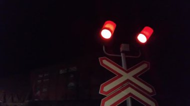 Bir halk treni gece vakti yol seviyesindeki bir geçitten geçer. Uzun yük trenleri gece demiryolunda hareket eder. Lojistik kavram.
