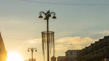 Şehrin tarihi merkezinde gün batımında binaların siluetlerini ve sokak ışıklarının panoramik görüntüsü. Kentsel kavramlar.