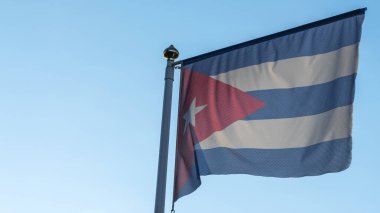 Ulusal Küba bayrağı mavi gökyüzünün önündeki bayrak direğinde güneş ışınları ve merceklerle parlıyor. Diplomasi konsepti. Uluslararası ilişkiler. Metin için boşluk.