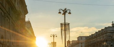 Şehrin tarihi merkezinde gün batımında binaların siluetlerini ve sokak ışıklarının panoramik görüntüsü. Kentsel kavramlar.