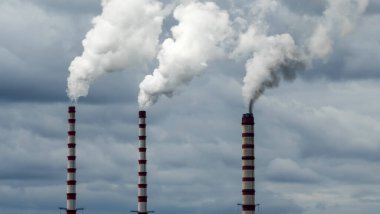 Gökyüzü arka planında bacadan çıkan endüstriyel duman. Kömür santralinden çıkan gri dumanlı yüksek baca borularının görüntüsü. Fosil yakıtlı elektrik üretimi. Rüzgâr kirliliği.