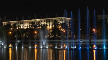 Geceleyin bir nehirde çok renkli bir müzik çeşmesi. Aydınlanmadan kaynaklanan gece çeşmesi. Mesaj için yer var. Kutlama konsepti.