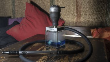 Tahta masadaki nargile kare matarası. Orijinal kare tasarımcı nargile.