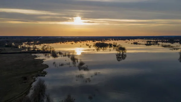夕日の空中ビューは 暖かい春の夜に満開の川の上にゆっくりと浮かんでいる積雲を美しく照らす 川の上の夕日のパノラマ — ストック写真