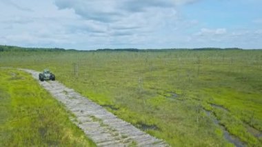 Alçak basınçlı tekerlekleri ve ulaşılması zor lastikleri olan özel bir off-road arabası. Her yere yayılmış bir araç. Dramatik gökyüzü arka planında bataklık için ekolojik taşıma.