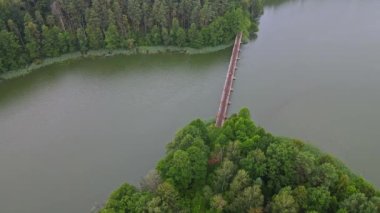 Dar göstergeli demiryolu ile köprünün yukarıdan aşağı görüntüsü. İnsanlar demiryolu tramvayında suyun üzerinde seyahat ediyorlar. Macera konsepti.