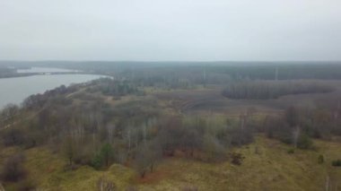 Sisteki sonbahar tarım alanlarının en üst görüntüsü. Büyük bir şehir ve göl yakınlarındaki sonbahar tarlalarını kaplayan sis ve sis.