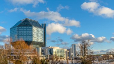 Halka açık. Belarus 'taki modern Ulusal Kütüphane binasıyla klasik mavi gökyüzü ve bulutlar. Mesaj için yer var. Belarus Kültür ve Bilimin Meşhur Sembolü.