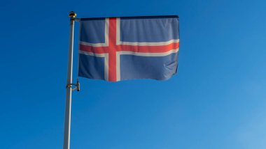 İzlanda bayrağı mavi gökyüzü arka planında. Gökyüzüne karşı rüzgarda dalgalanan İzlanda bayrağı. Diplomasi konsepti. Uluslararası ilişkiler. Metin için boşluk.