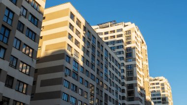 Yüksek binaların yakınındaki sıkışık avlu. Mavi gökyüzünün arka planında büyük bir apartman. Komşuluk kavramları.