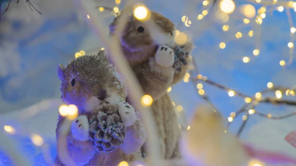 树下站着两只有趣的啮齿动物玩具 灯光照射的前景暗淡 购物中心和商店橱窗的装饰 圣诞节的概念 — 图库照片