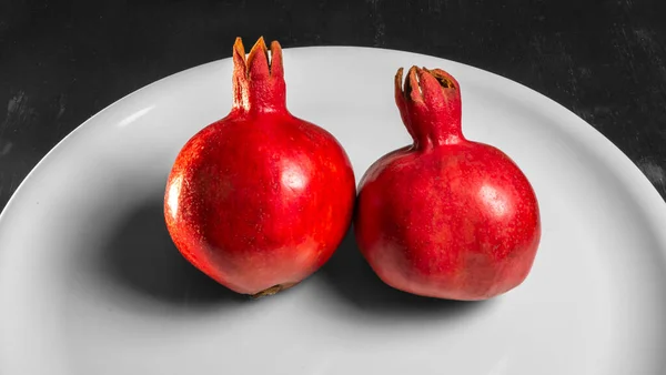 Δύο Φρούτα Ζουμερό Ισπανικό Ρόδι Πιάτο Πορσελάνης Σκούρο Φόντο Υγιείς — Φωτογραφία Αρχείου