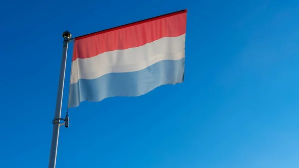 Государственный Флаг Люксембурга Флагштоке Перед Голубым Небом Солнечными Лучами Бликами — стоковое фото