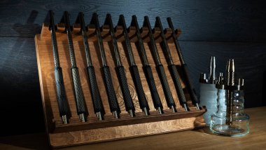 Ahşap bir kutuda nargile ve shisha dükkanında satılık iki küçük nargile için modern ağızlık seti. Nargile dükkanı reklamı için görüntü. Nargile 'nin koyu ahşap arka plandaki parçaları..