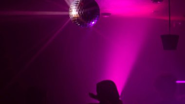 Disko topuyla parti atmosferi. Disko topundan yansıyan ışık demetleri.