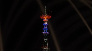 Televizyon kulesi festival aydınlanmasında. Ön plandaki çeşmede uzun süre su damlası var. Minsk Günü, nehirde havai fişeklerle kutlanıyor.