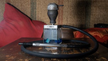 Tahta masadaki nargile kare matarası. Orijinal kare tasarımcı nargile.