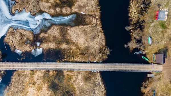 春の小川にかかる木造橋の空中風景 — ストック写真