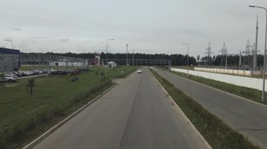 Test pistinde tur atan yeni bir elektrikli arabanın havadan görüntüsü. Elektrikli araba test sürüşü. Yeşil enerji kavramı.