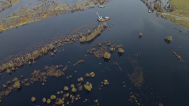 Dredger nehirdeki çim alanını derinleştirmeye çalışıyor. Nehirdeki bir tarakçı tarafından temizleniyor ve derinleşiyor. Nehirde gün batımı. Endüstriyel kavram.