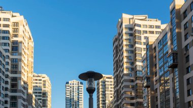 Yüksek binaların yakınındaki sıkışık avlu. Mavi gökyüzünün arka planında büyük bir apartman. Komşuluk kavramları.