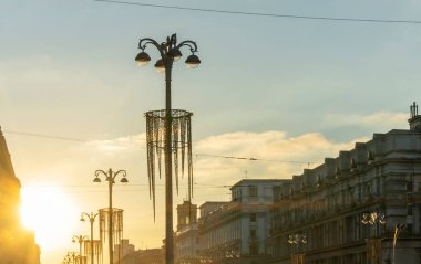 Şehrin tarihi merkezinde gün batımında binaların siluetlerini ve sokak ışıklarının panoramik görüntüsü. Kentsel kavramlar.