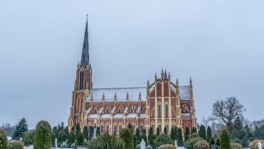 Kışın Gervyaty, Belarus 'taki Gervyaty kasabasındaki Neo-Gotik katedral kilisesinin dramatik manzarası. Mesaj için yer var. Din ve tarihi miras kavramları.