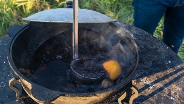 Büyük bir kazanda şarap kaynattım. Sıcak şarap büyük bir tencerede pişirilir. Geleneksel festivalde vitaminler. Çeşitli meyve ve baharatlarla sıcak şarap.