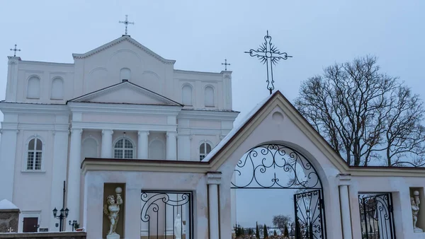 Ostrovets Grodno地域の聖人コスマスとダミアン教会は灰色の空を背景に木の枝を持ちます 崇拝と歴史遺産の概念 — ストック写真