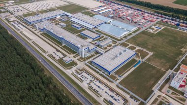 Gündüzleri endüstriyel kompleksin modern dış yüzeyi. Makineler için park yeri olan imalat yapısının hava görüntüsü.