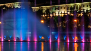 Geceleyin bir nehirde çok renkli bir müzik çeşmesi. Aydınlanmadan kaynaklanan gece çeşmesi. Mesaj için yer var. Kutlama konsepti.