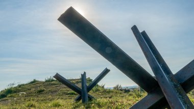 2. Dünya Savaşı 'ndan kalma demir tanksavar. Kirpi karşıtı dikenli tel mavi gökyüzü arka planında. Metin için boşluk.