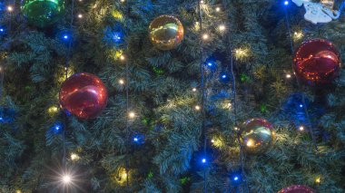 Süslü Noel ağacının yakın görüntüsü. Parlak mücevherler ve ışık çelenkleriyle süslenmiş güzel bir Noel ağacı. Noel ve Mutlu Yıllar kavramları.
