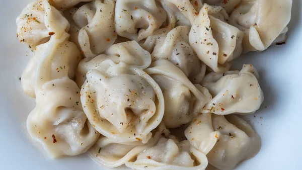 Kaynamış etli börek. Rus kaynamış pelmeni 'nin beyaz tabakta yakın plan görüntüsü. Haşlanmış ev yapımı Rus köftesi ya da etli pelmeni..