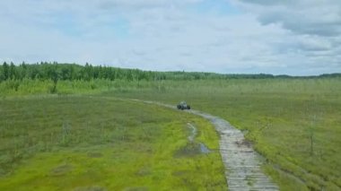 Alçak basınçlı tekerlekleri ve ulaşılması zor lastikleri olan özel bir off-road arabası. Her yere yayılmış bir araç. Dramatik gökyüzü arka planında bataklık için ekolojik taşıma.