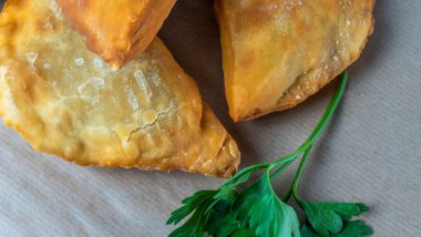 Lezzetli kızarmış chebureki soslu ve parşömenli maydanozlu. Fast food konseptleri. Aperatif. Sokak yemekleri..