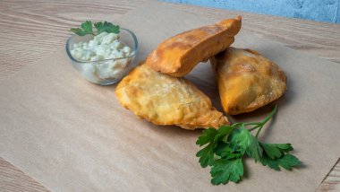 Lezzetli kızarmış chebureki soslu ve parşömenli maydanozlu. Fast food konseptleri. Aperatif. Sokak yemekleri..