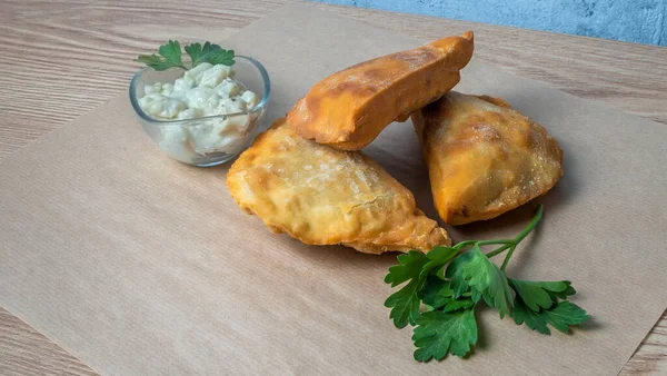 Lezzetli kızarmış chebureki soslu ve parşömenli maydanozlu. Fast food konseptleri. Aperatif. Sokak yemekleri..