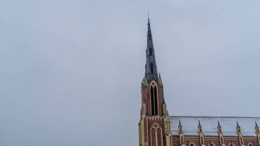 Kışın Gervyaty, Belarus 'taki Gervyaty kasabasındaki Neo-Gotik katedral kilisesi dramatik gökyüzü arka planında. Mesaj için yer var. Din ve tarihi miras kavramları.