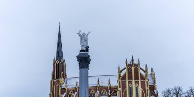 Geleneksel bir Başmelek Michael heykeli dramatik gökyüzüne ve kilise kulesine karşı şeytana mızrakla vuruyor. Mesaj için yer var. Din kavramları.