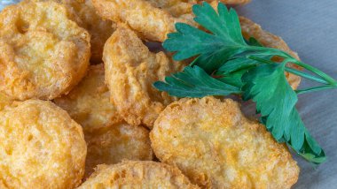 Krema soslu tavuk külçeleri ve parşömen üzerinde maydanoz. Çocuklar için nefis Amerikan yemeği, ev yapımı öğle yemeği. Fast food kavramları.