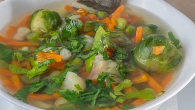 Yeşil fasulye, bezelye, havuç, patates, kırmızı dolma biber, domates ve kasede pırasadan yapılmış taze sebze çorbası. Taze sebze çorbası. Sağlıklı kavramlar.